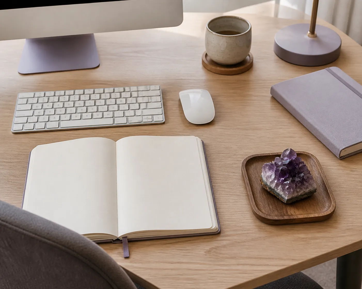 A small amethyst piece placed quietly on the right side of a desk without crowding the keyboard, notebook, or main task area