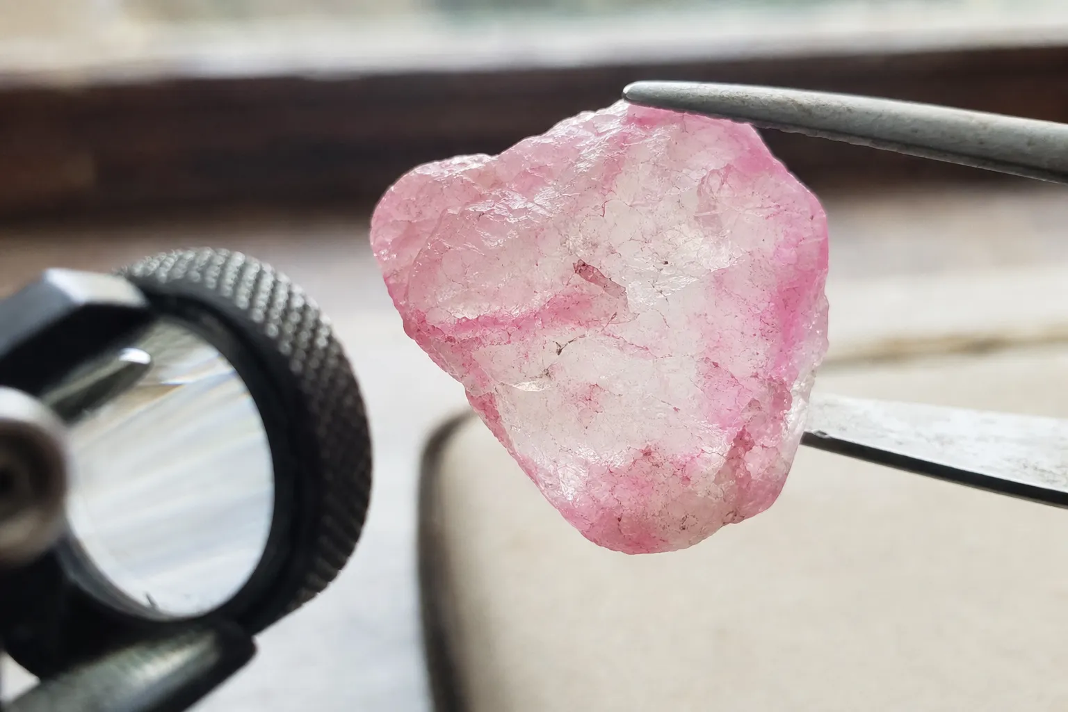 Close inspection of a pink quartz-family specimen showing color concentrated in cracks and edges